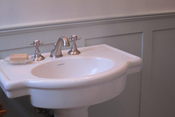 shaker panel in bathroom behind pedestal sink